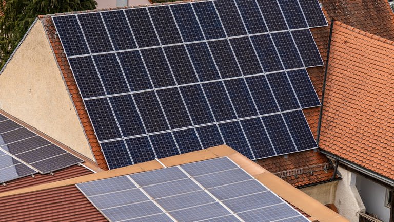 Hausdach mit Photovoltaik-Anlage - Kommunen steigen zunehmend in Energieprojekte ein, zum Beispiel Kusel